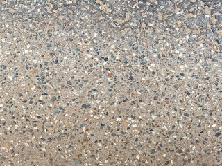 A textured concrete surface highlights an array of stones and minerals, showcasing its rugged beauty at a bustling construction site