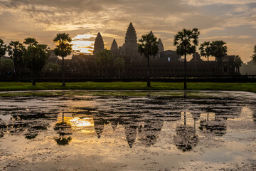 Naklejka premium Angkor Wat temple reflected in a pond at sunrise in Cambodia