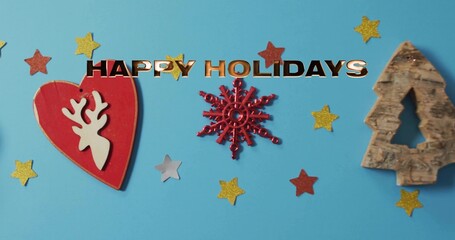 Placing red heart snowflake carved tree on blue backdrop adding star confetti metal HAPPY HOLIDAYS