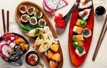 A table with Asian food, sushi, rolls, desserts. © bit24