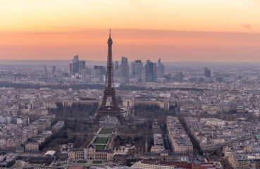 Obraz premium Paris, France - 03 03 2026: Montparnasse Tower: View of Eiffel Tower, Le Trocadero, Military School and The buildings of La Defense district at sunset from the rooftop