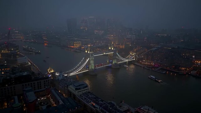 Atmospheric aerial view of the skyline of London, England, with Tower Bridge and City skyscrapers during twilight with thick fog