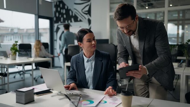 Caucasian businesswoman company leader boss consulting businessman manager showing digital tablet data asking help business man and woman discussing portable wireless computer tasks two office agents
