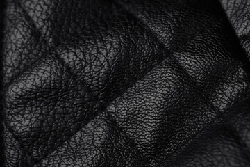 Fototapeta premium Detailed close up view of dark elegant black leather texture surface with unique creases and patterns