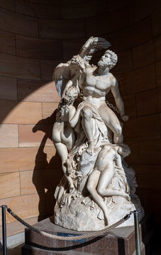 Marble sculpture of Prometheus bound and attacked by an eagle, surrounded by expressive figures in a classical museum setting.