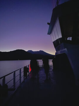Cielo morado por el anochecer en barcaza entre monta&ntilde;as y lago