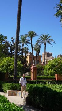 Traveler Walking Through Royal Alcazar Gardens in Seville Spain