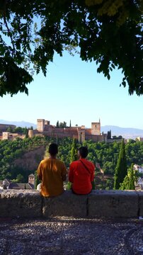 Travelers pointing at Alhambra palace in Granada Spain