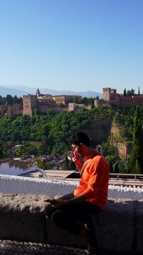 Young man taking selfie with Alhambra view in Granada Spain