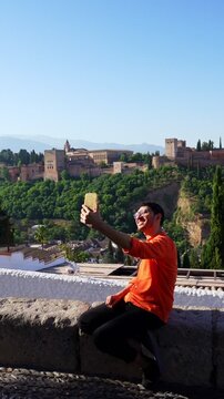 Solo Traveler taking selfie with Alhambra palace in Granada Spain