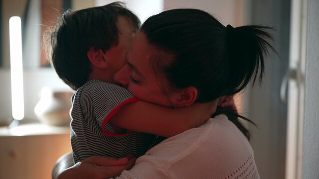Mother hugging son tightly, eyes closed in warmth and affection, showing deep emotional bond and love in a tender family moment