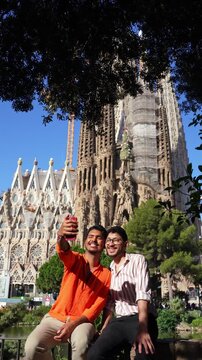 Gay couple taking selfie with Sagrada Familia Barcelona