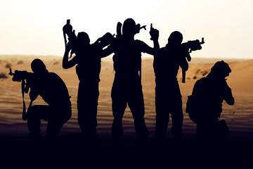 Obraz premium Silhouettes of soldiers prepare for conflict in a desert setting during Iran USA tensions