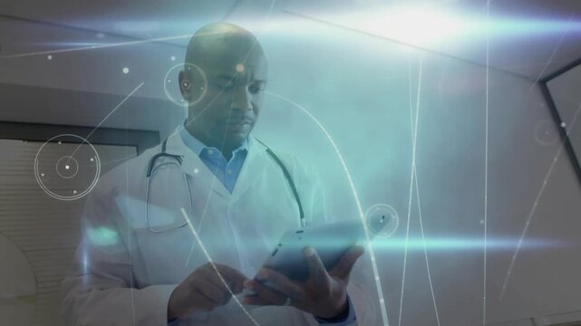 Doctor reading tablet then tapping and swiping to review medical data while holograms orbit tablet