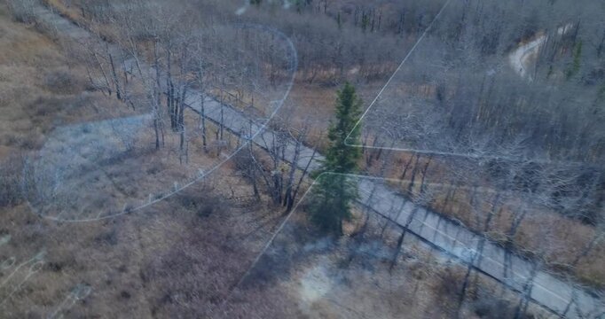 Drone flying forward camera panning trail, overlays shifting, mapping evergreen and tracking object