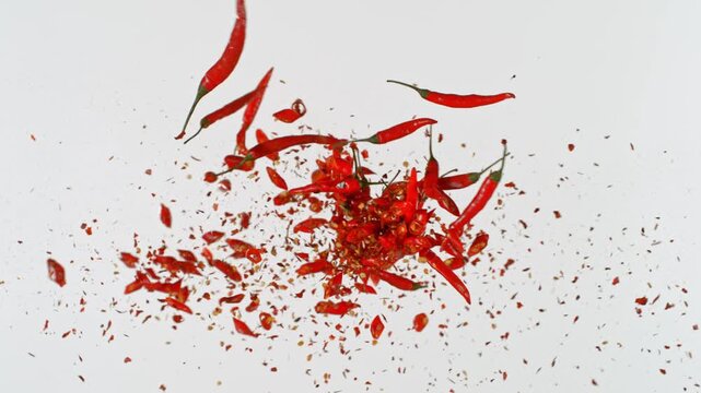 Chili Pepper Collision with Flying Powder and Seeds on White Background