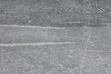 Fototapeta premium Close-up view of textured gray concrete surface with visible scratches and lines