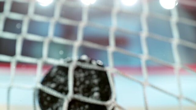 Super slow motion of ice hockey puck hitting the back of the net as it scores a goal