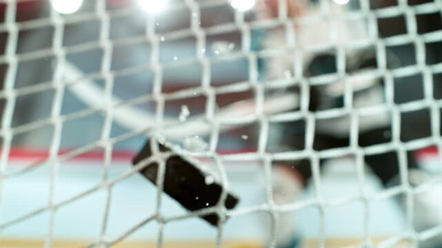 Super slow motion of ice hockey puck hitting the back of the net as it scores a goal
