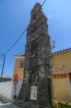 Agios Nikolaos church tower between village houses in Krini, Corfu, Greece  