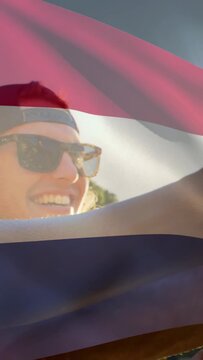 Vertical video: Guitarist starting music and strumming, flag overlay waving, friend lifting bottle