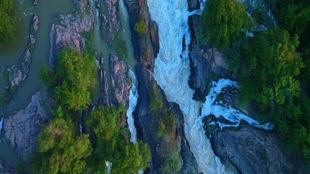 The thundering rapids of Li Phi Waterfall cut across the Mekong River, creating dramatic torrents, misty spray, and a striking tropical landscape from above.