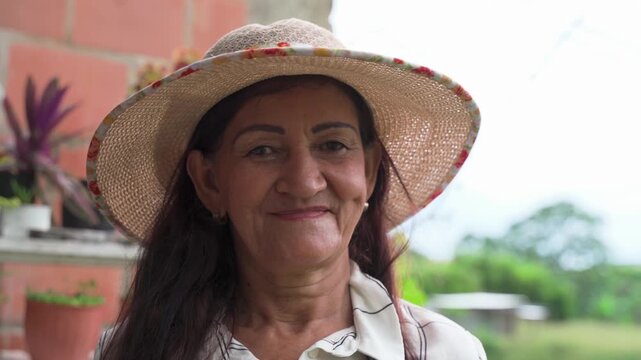 Colombian farmer woman in rural life looking happy at the camera in close-up