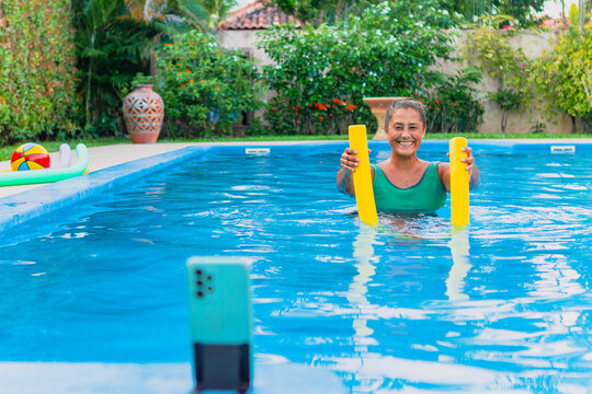 Woman enjoying pool exercise with floats and relaxation