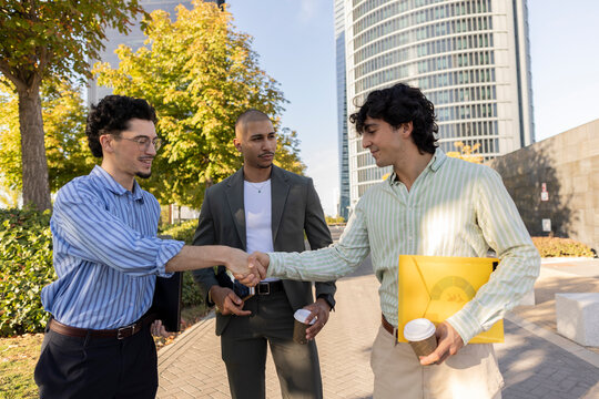 Businessmen shaking hands in urban environment