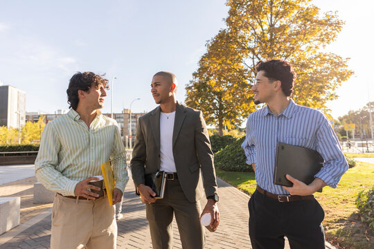 Businessmen discussing ideas during sunny city walk