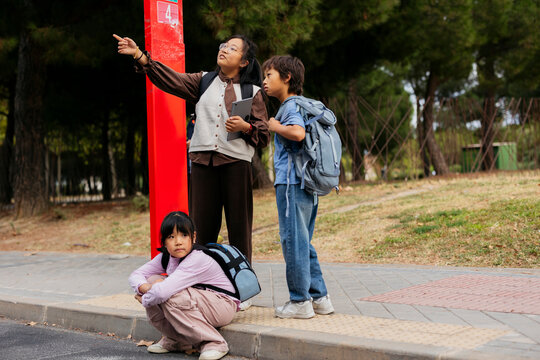 Asian children waiting at a bus stop