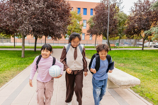 Asian children walking happily with school bags
