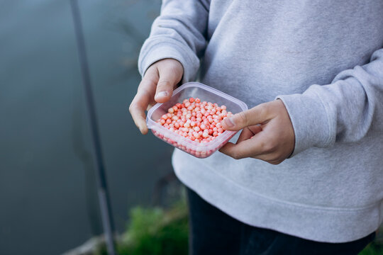 Young boy fishing with bait near a calming lakeside