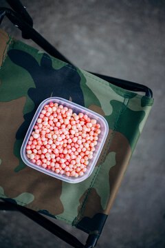 Fishing bait in a container on camouflage chair