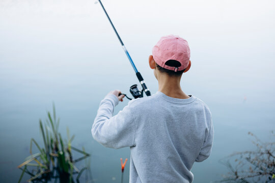 Teenage boy enjoys serene fishing by the lake