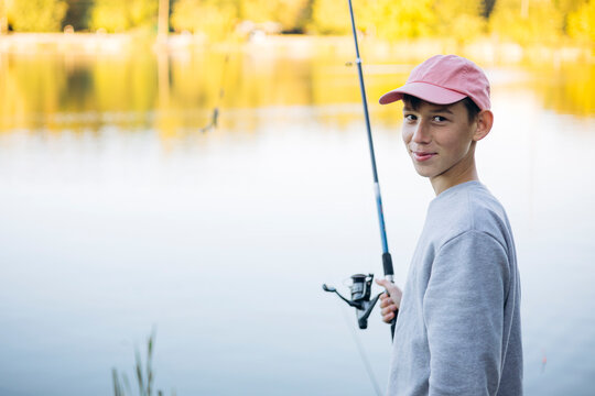 Teenage boy fishing by a serene lakeside