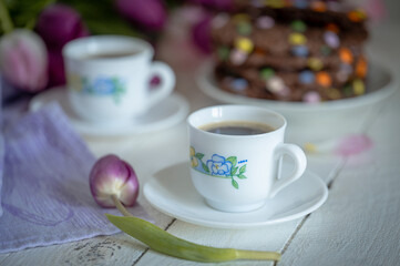 Fototapeta premium Cookies with colored dragees, coffee, and tulips. Food photo.