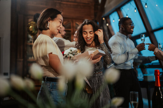 Happy friends gathering for a surprise birthday party, receiving gifts and celebrating a special event