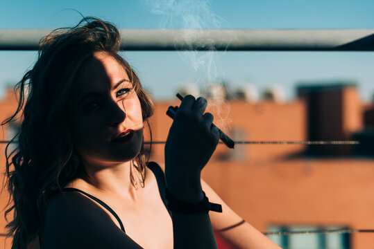 Woman smoking cannabis joint under the sun