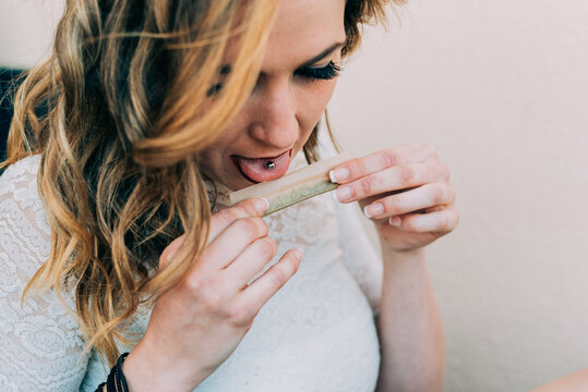 Woman preparing a cannabis joint with focus