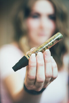 Woman preparing marijuana in a glass blunt