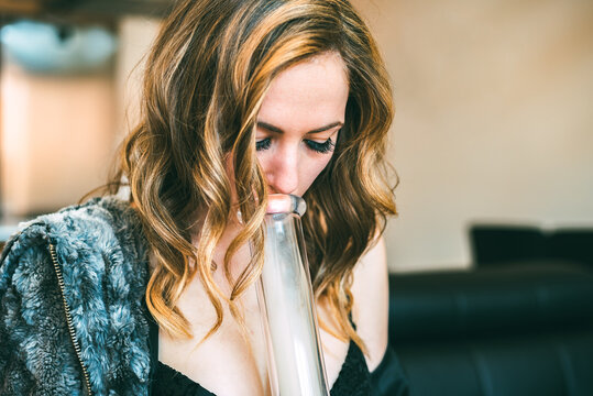 Woman using cannabis pipe indoors
