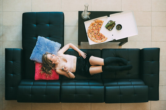 Woman relaxing on sofa with marijuana joint
