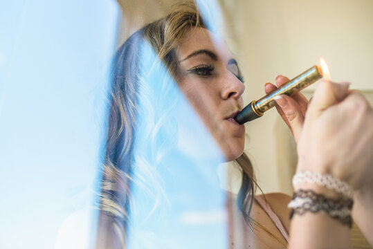 Woman using a glass blunt for cannabis consumption