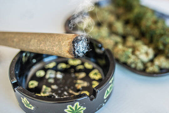 Smoking cannabis joint near decorative ashtray