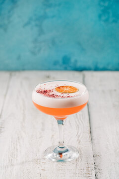 Elegant cocktail with citrus garnish on a wooden bar