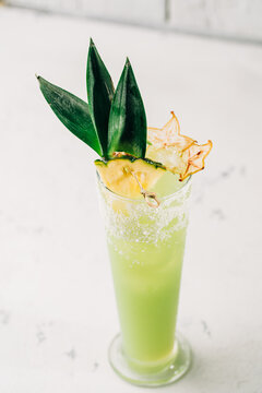 Tropical cocktail garnished with pineapple and starfruit