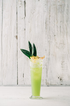 Refreshing green cocktail in a tall glass at a bar
