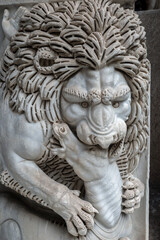 Fototapeta premium Intricately Carved Marble Lion Sculpture Gripping Human Figure Showing Detailed Mane and Expressive Face in Classical Stone Artwork in Rome, Italy