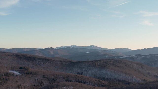 4K winter drone video of the snowy green mountains of Vermont and ski area trails covered in snow in the distance. Killington, New England, USA.